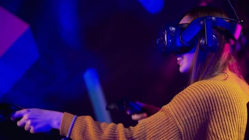 Frau spielt VR-Spiele in einem Studio mit blau-rosa Neonlichtern