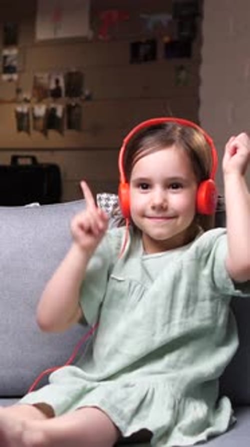 Girl Enjoys Music with Headphones on Couch