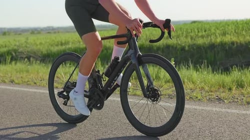 Adult Using Bike Computer While Riding Up Gentle Slope