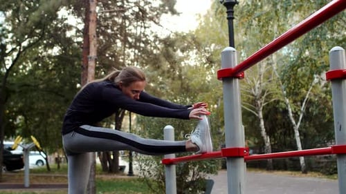 Woman in Sports Clothes Does Stretching Exercises on Street at Sports Ground Side View Beautiful