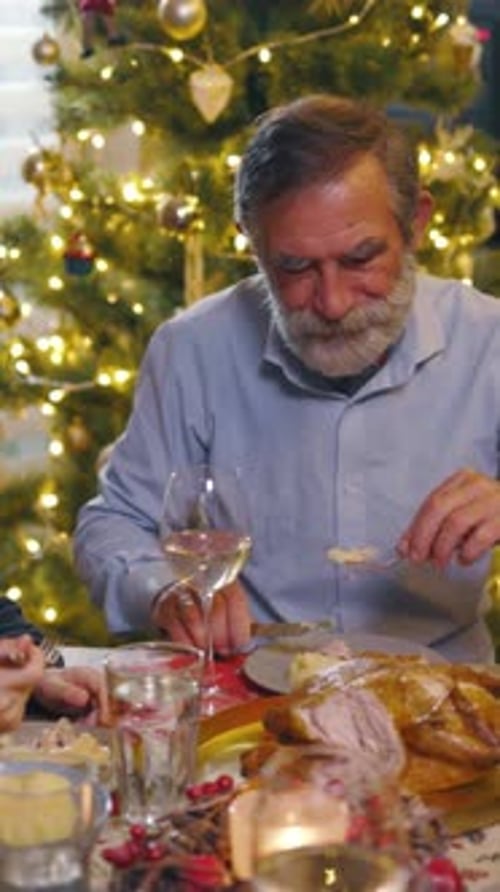 Senior Man Enjoying Christmas Dinner with Family