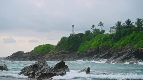 Ocean Waves Crashing Against Tropical Shoreline Rocks