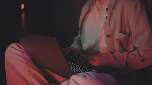 Smiling Woman Using Laptop at Night Indoors