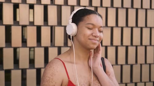 Woman Enjoys Music with Headphones in Urban Setting