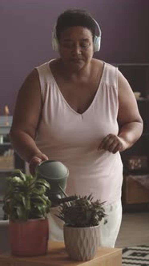 African American Woman Watering House Plants