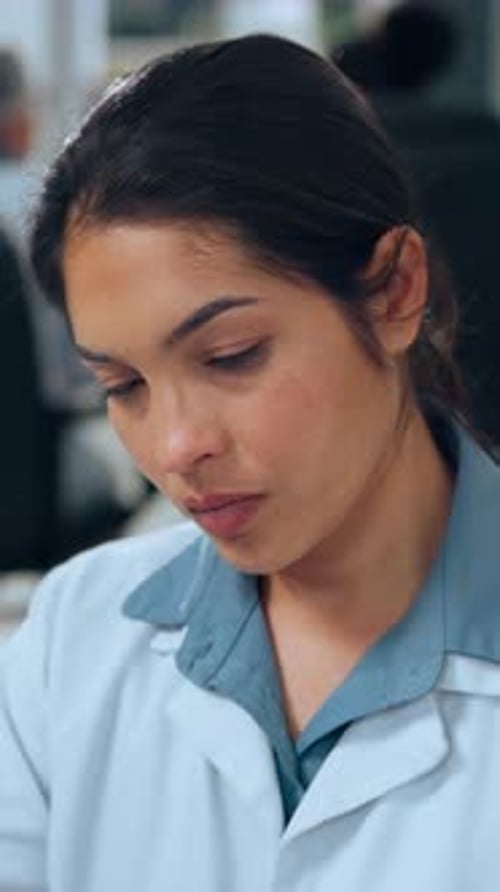 Woman in Lab Coat Experiencing Headache at Work