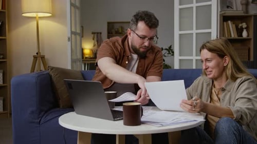 Couple Reviews Financials Together at Home on Couch