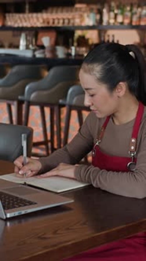 Female Administrator Working on Laptop in Restaurant