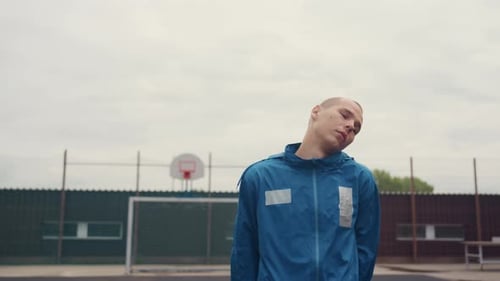Young Player Studies Cloudy Sky While Standing Quietly on Court Individual in Sports Attire Observes