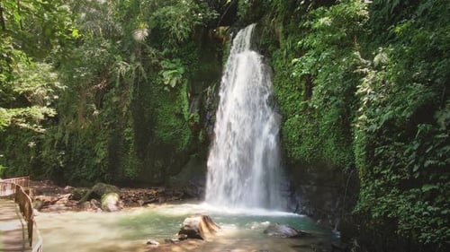 Aerial shot of beautiful hidden waterfall in green forest. Tropical mountain jungle waterfall in the