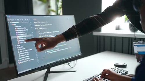 Two Young Adults Collaborating on Coding Project