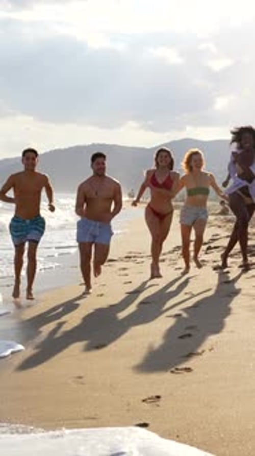 Happy friends running on the beach
