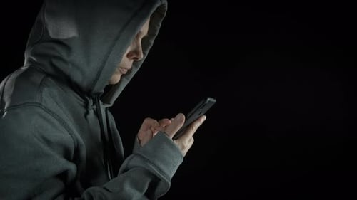 Hooded Person Types on Smartphone in the Dark