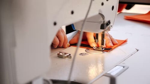 Close Up of Sewing Machine Stitching Orange Fabric