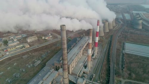 Aerial Drone View of Tall Chimney Pipes with Grey Smoke From Coal Power Plant Production of