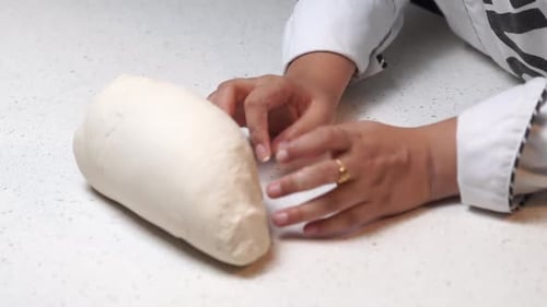 Hands Kneading Fresh Bread Dough on Counter