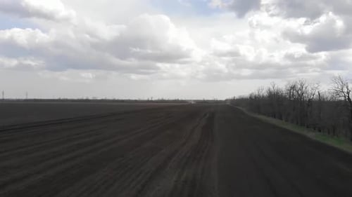 Blue tractor working on the field in Odessa in Ukraine during planting sunflower