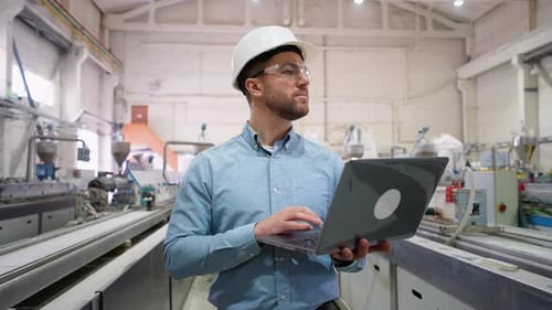 Chief Engineer With Laptop On Factory Analyzes The Production Process