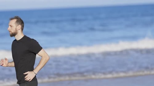 Athletic Man Running Barefoot on the Beach