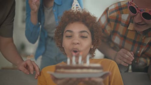 Birthday Celebration with Friends Blowing Out Candles