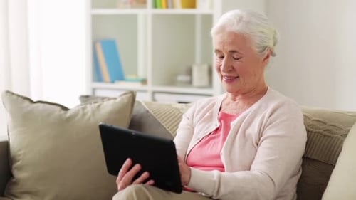 Smiling Senior Woman Using Tablet at Home