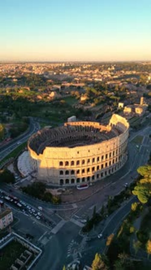 vertical aerial drone view Golden hour light illuminating the Colosseum in Rome