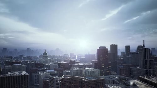 Vista aérea del horizonte de la ciudad iluminado al amanecer con neblina y fachadas de vidrio