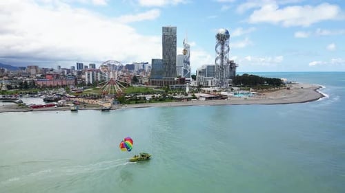 4k drone video of parasailing and water sport activities in front of Batumi skyline in Georgia. Skys