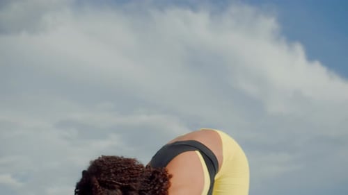 Young Woman Stretching Outdoors on Cloudy Day