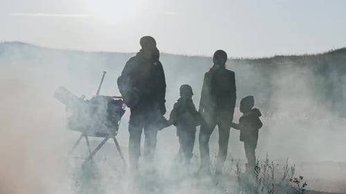 Silhouettes of Survivor Family in Gas Mask Standing Through Clouds of Toxic Smoke and Cinder in