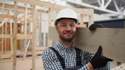 Construction Worker Carrying Wood on Shoulder