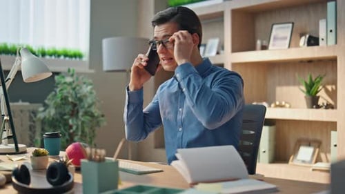 Young Adult Man Talking on Phone in Office