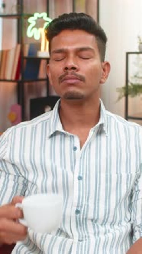 Young Adult Man Enjoying Tea in a Living Room