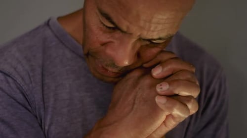 Mann betet mit zusammengefügten Händen auf grauem Hintergrund zu Gott — Stockvideos