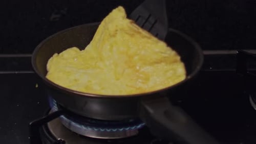 Omelet Cooking in Frying Pan Being Folded