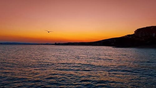 Beautiful sunset over calm sea waters. Vibrant orange and purple sky