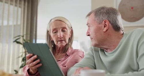 Senior Couple Uses Tablet at Home Together