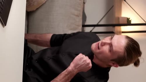 Frustrated Man Claps Hands at Table Indoors