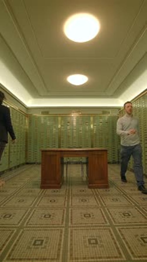 Un intérieur de voûte élégant avec des casiers verts et une table centrale pour plus de fonctionnalité
