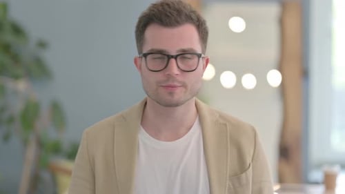 Man with Glasses Looking at Camera Indoors