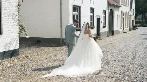 Beautiful wedding couple walking in a white dutch town in The Netherlands, (Thorn).