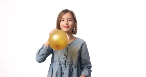 Girl Blows Up Gold Balloon for Birthday Party