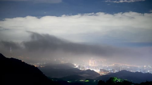 Nocturnal Marvel: City Lights and Shifting Cloudscape from the Summit.