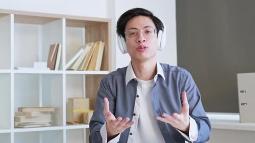 Young Adult Explaining with Headphones in Office Setting