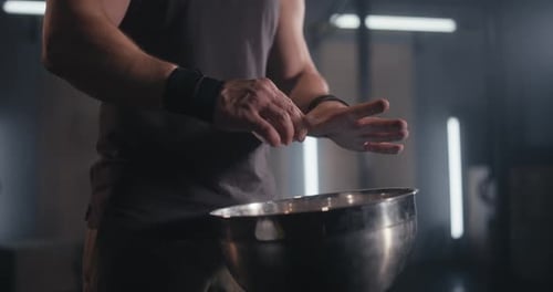 Muscular Man Chalking Hands Before Weightlifting Workout