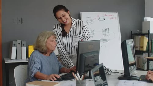 Adult Teaching Senior Computer Skills in Office