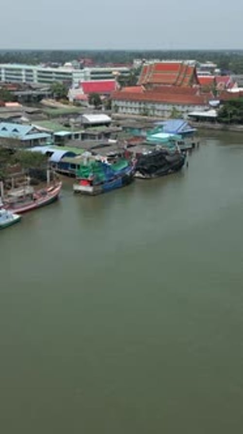 Un Drone s'approche de plusieurs bateaux amarrés au milieu de maisons