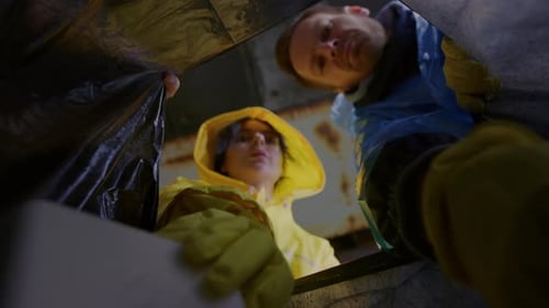 Bottom View Low Angle a Man and a Woman Put Waste in a Garbage Bag A Guy and a Girl are Putting