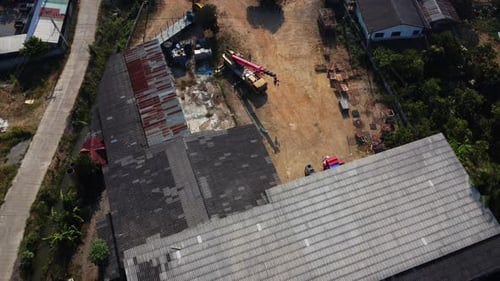 Mobile crane stands waiting to lift steel at a warehouse. Crane operators and mobile cranes