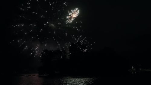 Festive fireworks reflecting in the lake water
